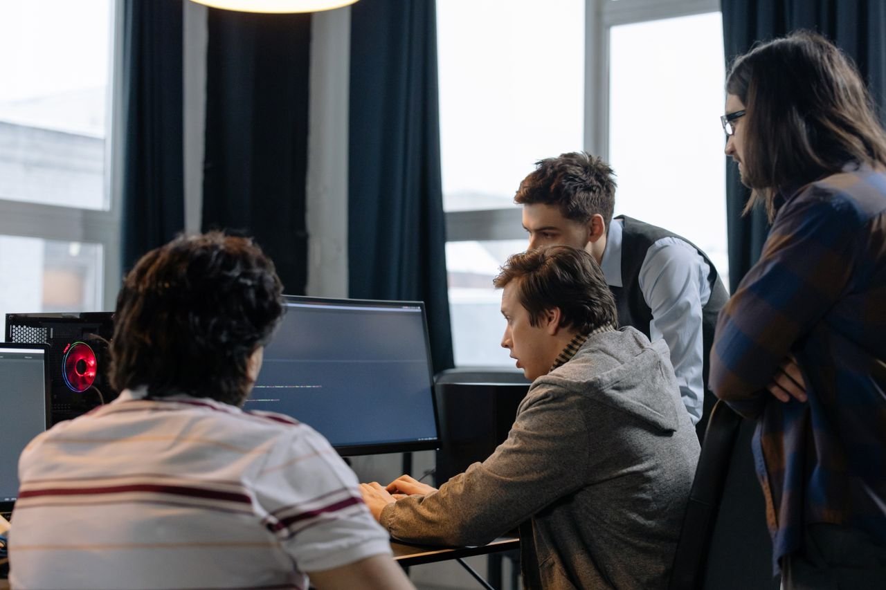 Mastering the First Impression: Your intriguing post title goes here Group of developers working together on a computer programming project indoors.